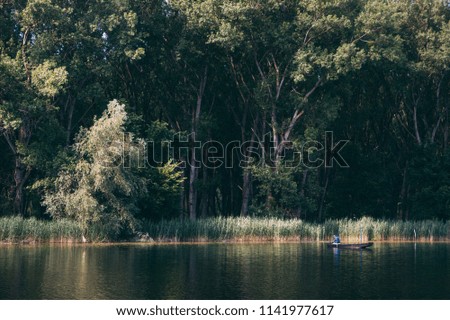small boat and fisherman on a big river summer day beautiful scenic scene