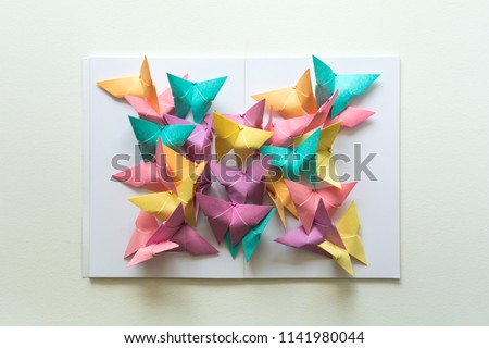 Mental health concept. Colorful paper butterflies sitting on book in shape of butterfly. Harmony emotion. Origami. Paper cut style.