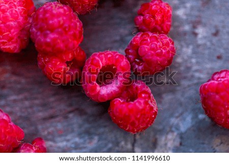 fresh raspberries scattered on a wooden background