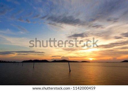 Long exposure shot of Lake view at Southern Thailand on sunset time background,Long exposure shot lake view with colored sky over lake on sunset time background.                 