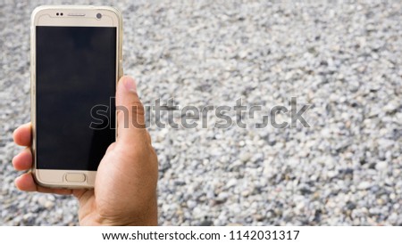 Man hand holding mobile smart phone with blank screen for advertising text message / logo design / promotional content graphic product display montage. Closeup of sending SMS or browsing the internet.