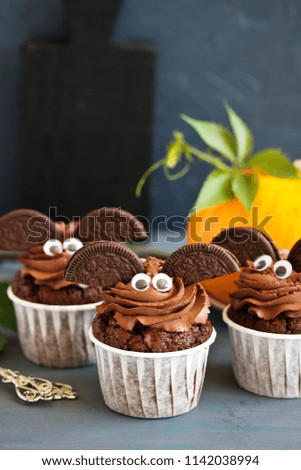 Chocolate muffins, with a chocolate cream in the form of bat on Halloween.