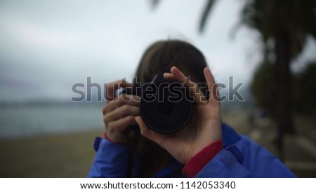 Girl photographer adjusting lens on camera, taking pictures at leisure, hobby