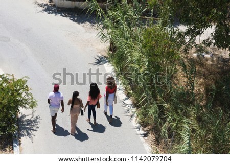 Top view of four black people friends walking along the street at afternoon