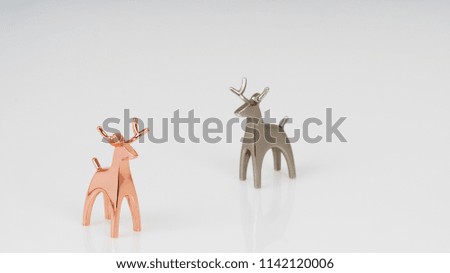 A nice golden and silver reindeer statue isolated on a white background. Lovely deer couple statue.
