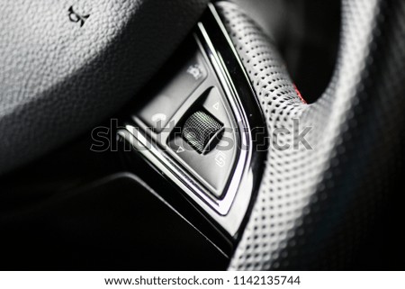 Volume control on steering wheel in modern car. Interior sound mount vehicle concept detail with signs.