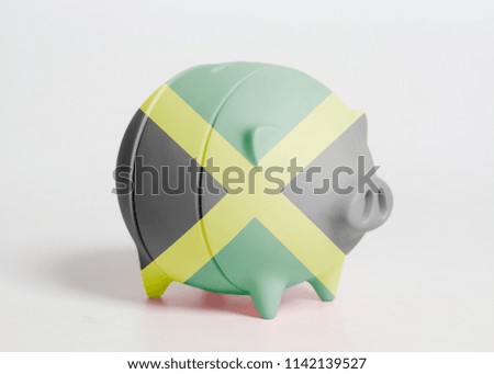Piggy bank with Jamaica flag isolated on white background