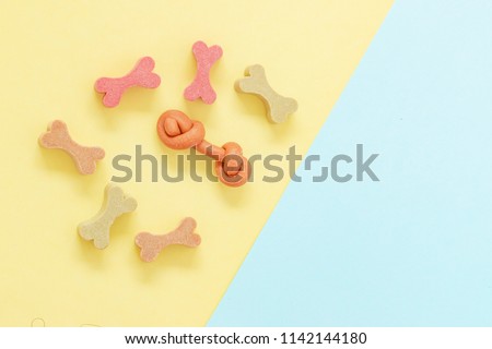 Delicious snack dog biscuits or dog treat of shape of bone on color background in copy space, Can use for background , Advertising for pet food product. Royalty-Free Stock Photo #1142144180
