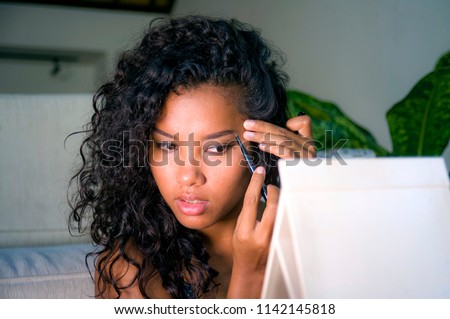 lifestyle portrait of young happy and beautiful latin American woman using eyebrow pencil drawing the contour applying face makeup looking and smiling at mirror in female beauty skin care Royalty-Free Stock Photo #1142145818