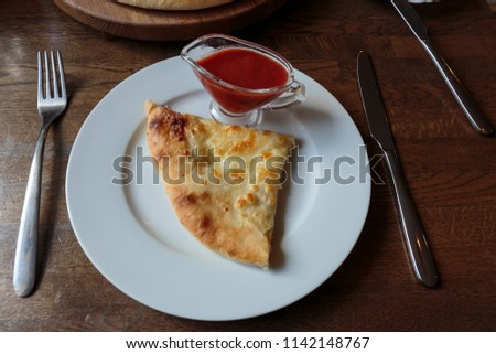 Slice of fresh cheese pizza in a plate, jug with spicy ketchup. Italian traditional appetizer.