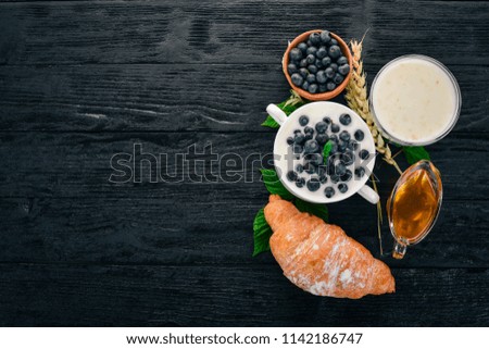 Yogurt with Blueberry. Breakfast. On a wooden background. Top view. Free space for text.