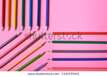 Color pencils on pink pastel background, close up. Set of colorful pencils, copy space. Crayons. Top view, flat lay. Back to school, college concept. Abstract background