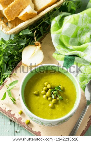 Diet menu. Puree soup with green pea in a bowl on a kitchen wooden table. The concept of healthy eating.
