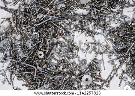 A lot of cogs, screws,  bolts and moods on a white background. Abstract photo.