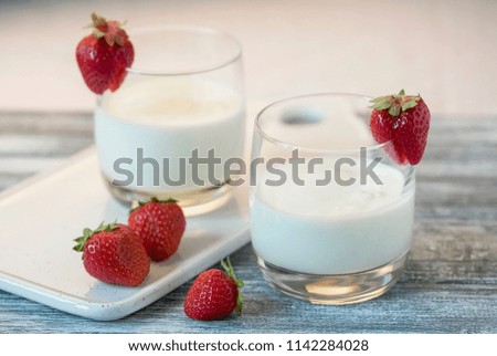 Yogurt with strawberry on wooden gray table