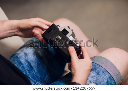 man installing photo film cartridge in film camera