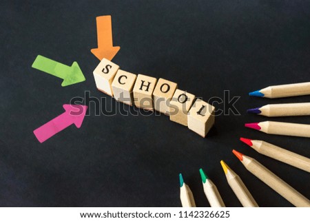 Word school written with wooden blocks on black background