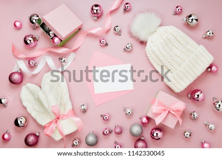 Warm winter clothes and Christmas decor. Arrangement in pastel pink colors.