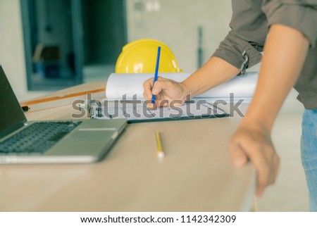 Asian woman civil engineer,architecture checking blueprint in tablet at working site.blue print is fake only for stock photo.

