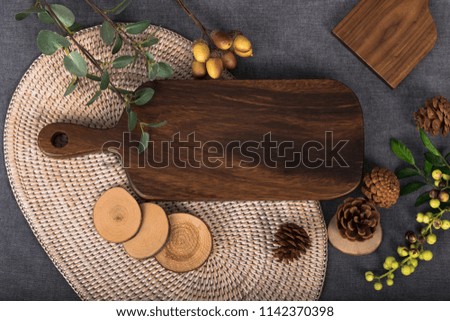A wooden table with autumn feeling and a table with fruit. A well-being meal preparation on a tablecloth of gray color, a photo image of a chopping board picture usable as a dining table menu.