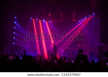Musical concert. People in the concert hall at the disco . Singer in front of the audience. Fans at the concert. Blurred image / blurred photo.  Royalty-Free Stock Photo #1142374067