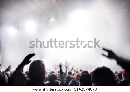 Musical concert. People in the concert hall at the disco . Singer in front of the audience. Fans at the concert. Blurred image / blurred photo.  Royalty-Free Stock Photo #1142374073