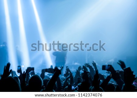Musical concert. People in the concert hall at the disco . Singer in front of the audience. Fans at the concert. Blurred image / blurred photo.  Royalty-Free Stock Photo #1142374076
