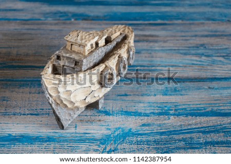 background. a light wooden boat stands on a blue wooden table. imitation of the sea.