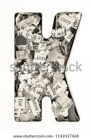 Capital letter made from cut up old newspaper Macro photography