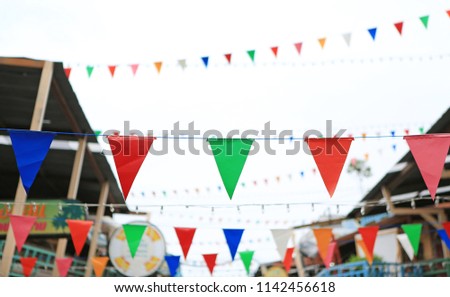 Multicolored Triangular Flags Hanging between old vintage house.