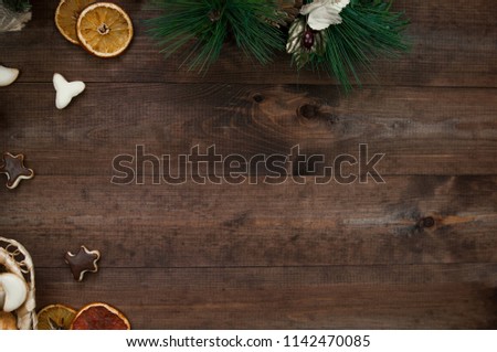 Christmas decoration, gift boxes, dry oranges, cinnamon and Christmas wreath frame background, top view with copy space on brown  wood table surface. 