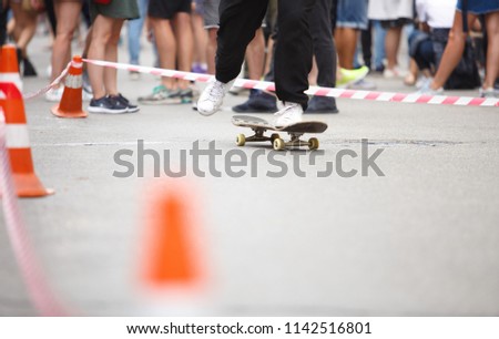 Feet of young skater boy riding on skateboard outdoor in summer. Extreme sports competition background. Ride skate board for fun
