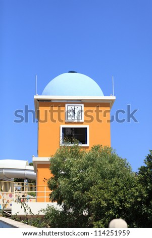 Yellow clock tower on the sky background, Greece