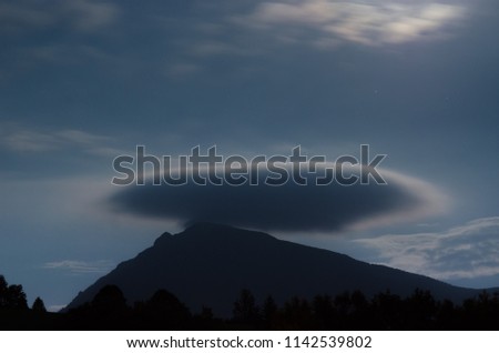 A fantastic oval cloud over the mountain. Moon light. 