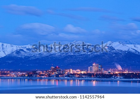 Anchorage Alaska skyline in winter at dusk with the Chugach mountains behind. Royalty-Free Stock Photo #1142557964
