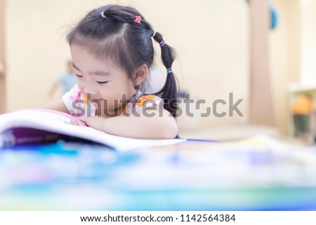 Lovely young asian girls read books in the library