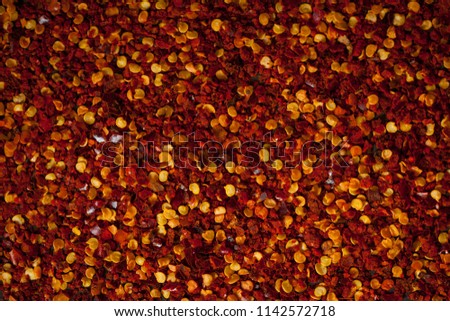 food dark background with scattered flecks of salt and red pepper or paprika. spices mix on rough textured surface. free space concept