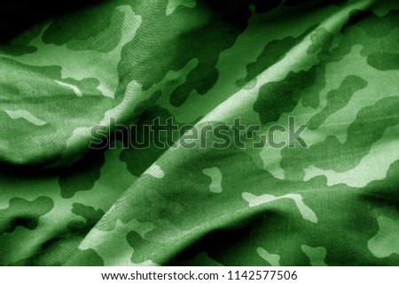 Military uniform pattern with blur effect in green tone. Abstract background and texture.