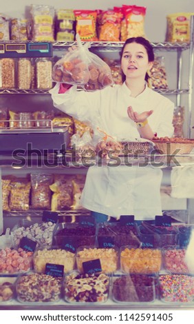 Young girl demonstrates a selection of sweets and pastries in the store