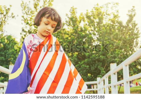 Patriotic girl with Malaysian flag in spirit of Merdeka (Independence Day)