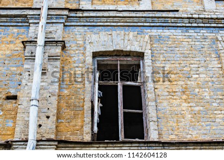 Abandoned brick house with broken windows
