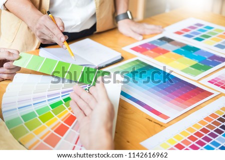 Professional Creative architect graphic desiner occupation choosing the Color pantone  palette samples for project on office desktop computer