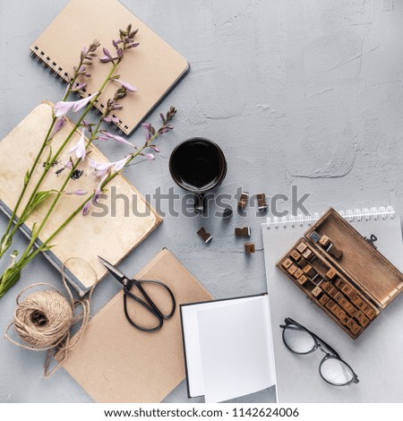 Hipster student objects flatlay with book, plants, leaves, glasses, cards, coffee cup, frame, flower, notebook. Creative work table for photographer, traveller, blogger. Working space surface top view
