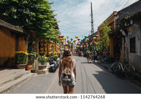 Tourist woman with backpack is wearing hat and enjoy sightseeing at Heritage village in Hoi An city in Vietnam. Travel Asia