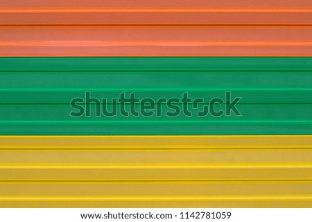 A new fence of multi-colored siding. Background, texture, wallpaper. Orange, green, yellow. Copy space