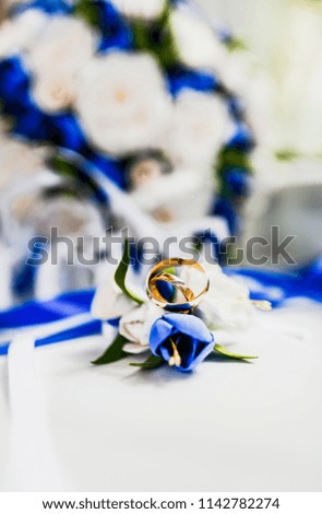 a bridal bouquet and a groom's boutonniere, on which were put wedding rings from gold