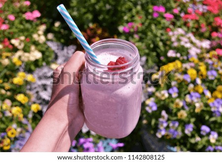 banana strawerry and raspberry smoothie. flowers background