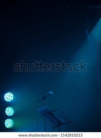 Empty music stage background photo with microphone and blurred blue green LED lights 