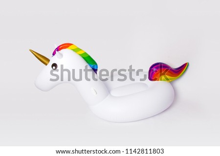 White, trendy, blown beach unicorn isolated on a white background. Hit the summer. Inflatable unicorn mattress.