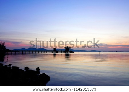 Silhouette Jetty in to the sea in Long exposure image of dramatic sunset or sunset,Colored sky and clouds over tropical sea scenery landscape,Selective soft focus,Ideal use for background.